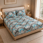 A bed dressed in a gray geometric patterned sheet set with matching pillowcases, styled in a warm, modern bedroom with a wooden bed frame, bedside tables, and warm lighting.