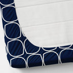 Navy blue and white geometric patterned fitted sheet on a mattress corner.