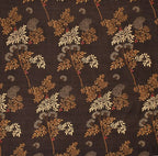 Floral patterned fabric with leaves and branches on a brown background