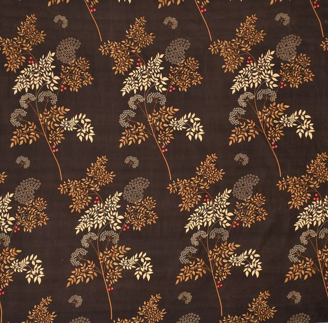 Floral patterned fabric with leaves and branches on a brown background
